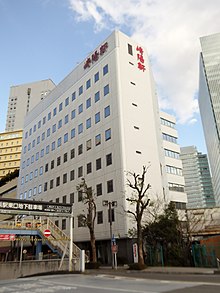 本社があるヨコハマジャスト1号館（右）と、横浜駅東口地下駐車場 ポルタ側出入口（左下）