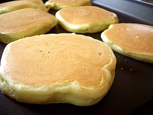 Pancakes being cooked on a griddle.