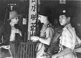 Police question a civilian during the Malayan Emergency. Counterinsurgency involves action from both military and police authorities. Police in Malayan Emergency.jpg