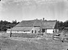 Boerderij, fraai tegen de rand van het dennebos gelegen, met dubbel hooivak en inritten aan de lange zijden; uitgebouwd woonhuis met houten top