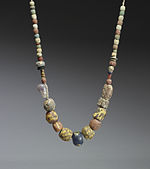 A 6th-7th century necklace of glass and ceramic beads with a central amethyst bead. Similar necklaces have been found in the graves of Frankish women in the Rhineland. Frankish - Necklace - Walters 47596 - View A.jpg