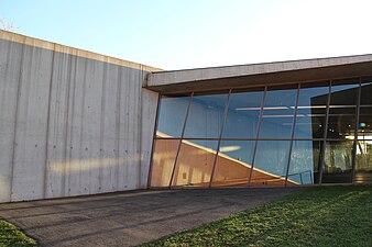 A view of the art gallery space behind the window. The reflection of other buildings in the Vitra Fire Station give a small sense of the other Vitra campus buildings.