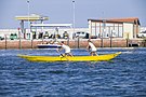 dos mujeres remando en un barco amarillo en un día soleado