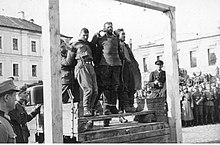Three men about to be hanged in front of a large crowd of Wehrmacht soldiers Egzekucja zakladnikow przez powieszenie (2-1837).jpg