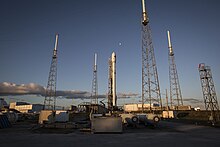 SLC-40 with SpaceX Falcon 9 launch infrastructure. The four towers surrounding the rocket are lightning arresters, and acts like a giant Faraday cage Falcon 9 preparing to launch DSCOVR (16673054016).jpg