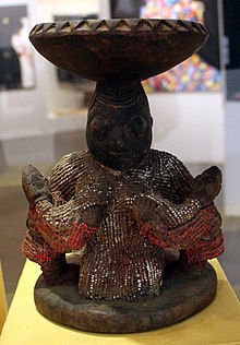 Escultura de ébano que representa a Yemayá amamantando a los Ibejis, uno con cada mano