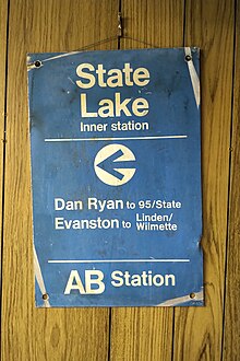 A blue metal sign, worn at the corners, with the following text in white Helvetica font: "State Lake Inner station ← Dan Ryan to 95/State Evanston to Linden/Wilmette AB Station"