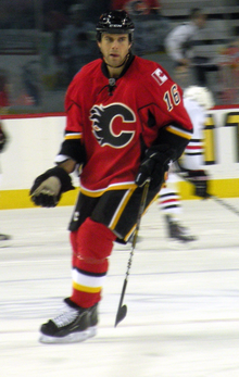 Photographie d'un joueur de hockey avec un maillot rouge sur le dos