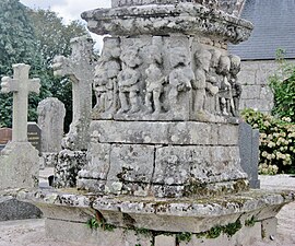 Locuon ː la base du calvaire, illustrant la Passion du Christ, du calvaire situé dans l'enclos paroissial de l'église Saint-Yon.