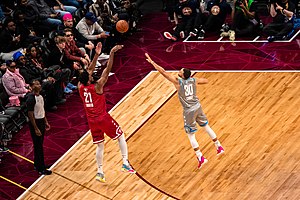 Joel Embiid shoots a three-point shot over Stephen Curry during the 2022 NBA All-Star Game. Joel Embiid and Steph Curry (51916472728).jpg