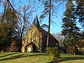 Kirche mit angebautem Pfarrhaus und Einfriedung, Denkmal für die Gefallenen des Ersten Weltkrieges sowie vier Grabanlagen und ein Grabmal auf benachbartem Friedhof