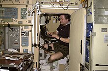 Cosmonaut Nikolai Budarin at work inside the Zvezda service module crew quarters Nikolai Budarin in a sleep station in Zvezda.jpg