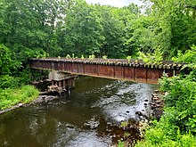 An abandoned railroad bridge over a small river