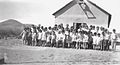 The teacher and her students in front of the schoolhouse in the 1930s.
