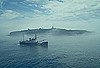 Маяк тендера USCGC Пихта в море на мысе Лести, Вашингтон, на заднем плане.