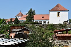 Zámek Ujčín – vpravo se nachází sýpka, v pozadí zámek s arkádovou chodbou