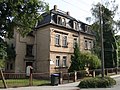 Wohnhaus in offener Bebauung und Stützmauer