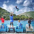 Un kiteboarder álzase sobre os entusiastas fans en Saba Rock Resort, Illas Vírgenes Británicas