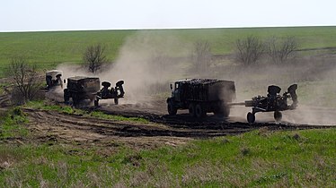 Um grupo de obuseiros M777 do Exército da Ucrânia sendo transportados por caminhões KrAZ-6322 durante a Invasão da Ucrânia pela Rússia em 2022