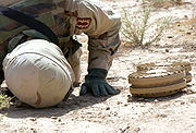 May 18, 2004. Staff Sgt. Kevin Jessen checks the underside of two anti-tank mines found in a village outside Ad Dujayl, Iraq in the Sunni Triangle.