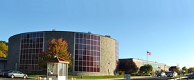 High school building, with a round auditorium in the foreground and a two-story rectangular brick building in the background