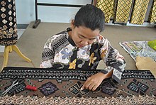 Tapis craftswoman embroider the basic design pattern in the tapis-making process at Lampung, Indonesia Dekranasda Lampung - panoramio.jpg