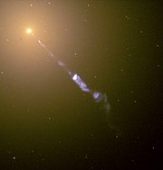 The jet originating from the center of M87 in this image comes from an active galactic nucleus that may contain a supermassive black hole.  Credit:  Hubble Space Telescope/NASA/ESA.
