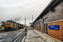 Maywood Commuter Station with CSX freight train passing