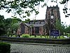 A Gothic church with a squat west tower and a clerestory with large rectangular windows