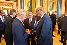 King Charles III speaking with Governor-General Cornelius A. Smith and Prime Minister Philip Davis at Buckingham Palace, 2023 Realms Lunch Coronation Event (52871679967).jpg
