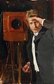Das Ölgemälde zeigt den Fotografen Christian Franzen. Hinter ihm steht eine Kamera auf einem Stativ, deren Auslöser er in der Hand hält. Mit der anderen Hand schirmt er seine Augen ab, um das zu fotografierende Motiv besser sehen zu können.