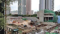 Another view of the construction site with the concrete structure of a station entrance completed