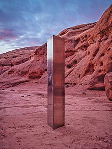 A metallic pillar with rectangular sides in a sandstone canyon