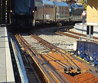 Bahnhof Zweisimmen: Ein auf Normalspur vor der Umspuranlage im Gleis 6 stehender GPX-Zug; am Ende eine MOB-Lokomotive, die den Zug durch die Anlage und weiter nach Montreux schieben wird. Die BLS-Lokomotive, die den Zug von Interlaken Ost brachte, ist durch die Anlage weggefahren.