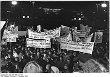 In der Nacht ziehen hunderte Demonstranten nach links vorüber und halten dabei zahlreiche Tafeln und Transparente in die Höhe