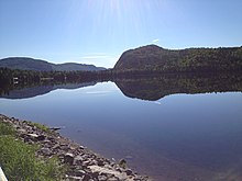 Lac avec une montagne en forme de chapeau en arrière-plan.