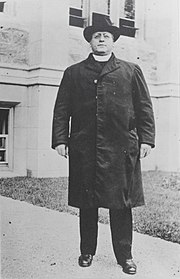 Charles W. Lyons standing with hat