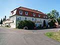 Gasthof „Holländische Mühle“ (zeitweilig auch Zollhaus) mit Saal-Anbau und vier Mühlsteine vor dem Gasthof