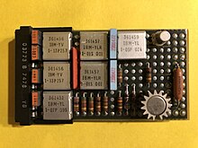 A single-width SLT card. Each square metal can contains a hybrid circuit with several transistors. IBM SLT card 03773.agr.jpg