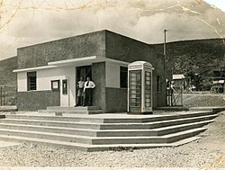 סניף הדואר כפי שצולם בשנת 1938. כשליד בית הדואר ניצב תא טלפון אדום בסגנון בריטי מדגם K6.