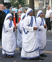 Four nuns in sandals and white-and-blue saris