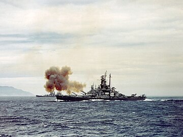 L'USS Indiana (BB-58) tirant sur la ville et les aciéries de Kamaishi, le 14 juillet 1945.