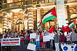 Pro-Palestine activists holding a sign reading "Free All Palestinian Political Prisoners" in Portugal.