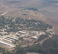 Vue aérienne de bâtiments sur une hauteur, au milieu des champs.