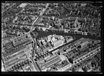 Luchtfoto van de Roetersstraat en omgeving, gezien in noordelijke richting. In het midden onder de Roetersstraat. In het midden van links naar rechts de Plantage Muidergracht. Daarachter de Plantagebuurt; circa 1930. Luchtvaartafdeeling, 1920-1940.