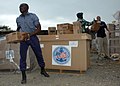 Ein Angehöriger der ghanaischen Marine, der kamerunischen Marine und der US Navy entladen gespendete Hilfsgüter für das APS-Projekt, Sekondi, 26. Februar 2009, 002