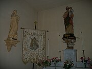 À droite saint Joseph tenant dans ses bras l'Enfant Jésus, à gauche saint Jean l'évangéliste, au centre l'Assomption de Marie broder sur un tissu.