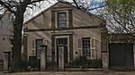 A rectangular house with its narrow side towards the street. This end has a 6-panelled door flanked by louvred sashes, mide 19th century. On the clipped end appears the date 1889, which probably refers to the roof alteration. These properties form an integral part of the historical and architectural nucleus of Paarl. The houses on these erven, the majority of which date from the nineteenth century are representative of the Cape Dutch, Georgian. Victorian and Edwardian styles