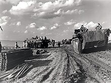 Column of Alligator amphibious vehicles passing Terrapin amphibious vehicles on the Scheldt river, October 1944 Alligators passing Terrepin amphibious vehicles.jpg