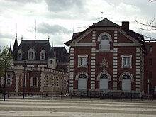 Bâtiments de briques rouges et de tuffeau blanc.